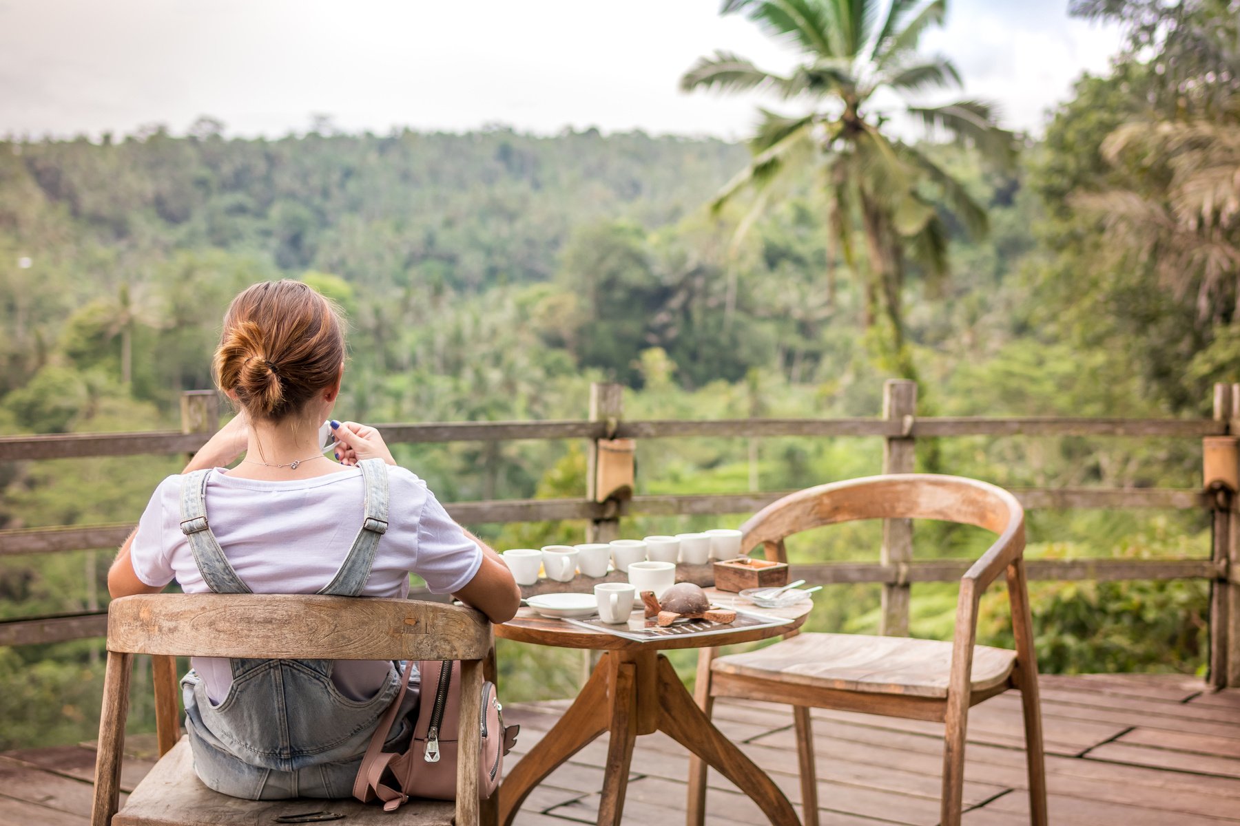 Brown-haired Woman Sitting on Brown Wooden Chair on Patio